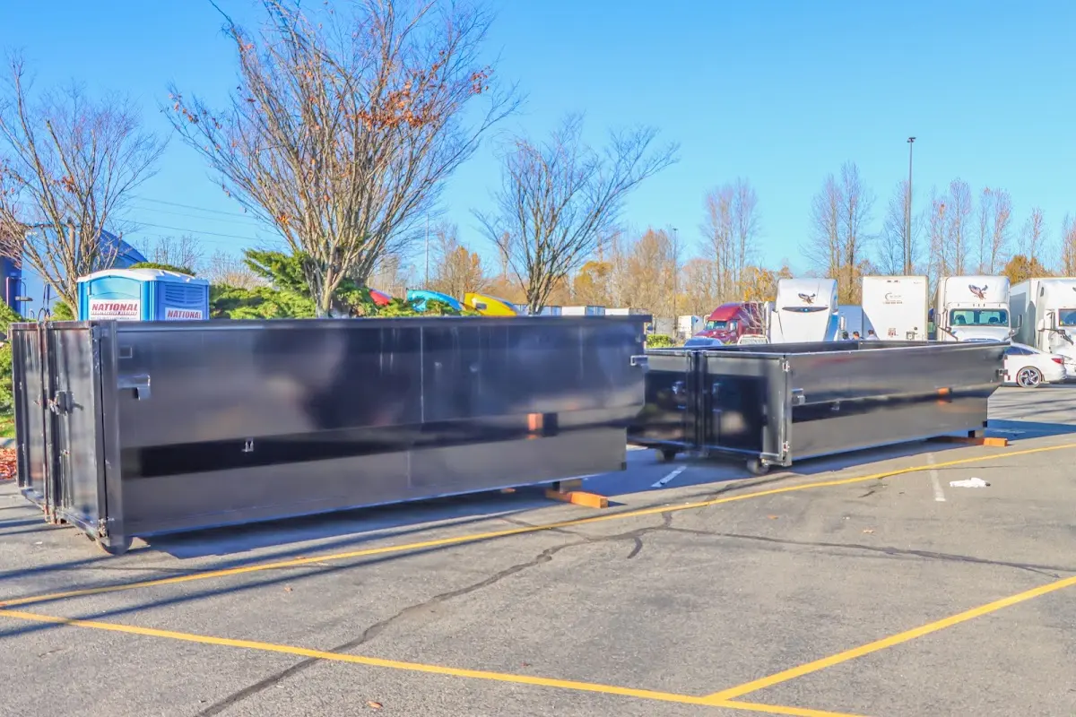 Professional dumpster rental service with roll-off container on residential driveway in Monroeville